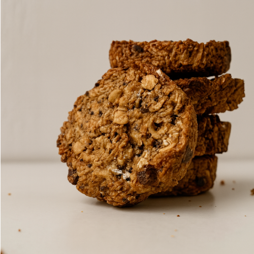 Cookies healthy à l’avoine, chocolat noir et amandes Teyni & Sweet, texture croustillante, présentés empilés sur fond clair.