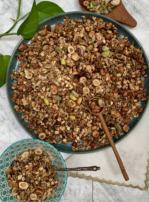 Granola premium artisanal aux pistaches, noix de cajou, noisettes et graines, présenté en plat
