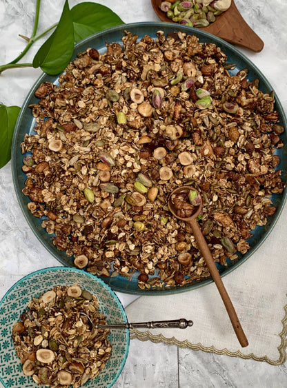 Granola premium artisanal aux pistaches, noix de cajou, noisettes et graines, présenté en plat